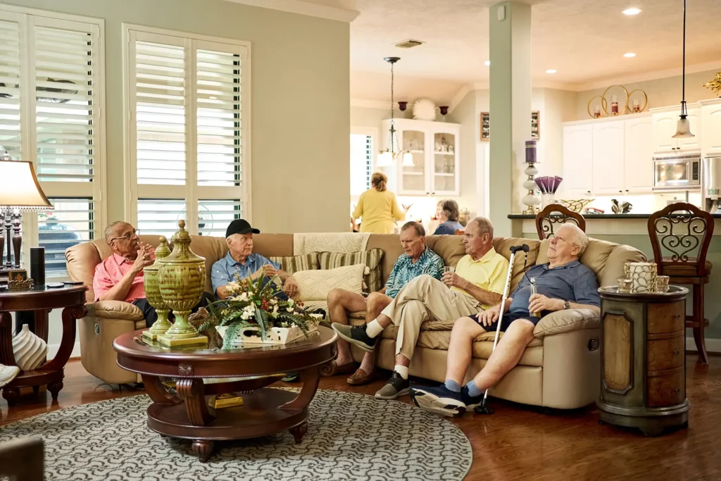 Senior male residents sitting on a sofa and talking